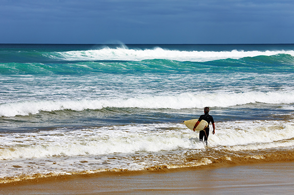 surfer at ninety mile beach new zealand