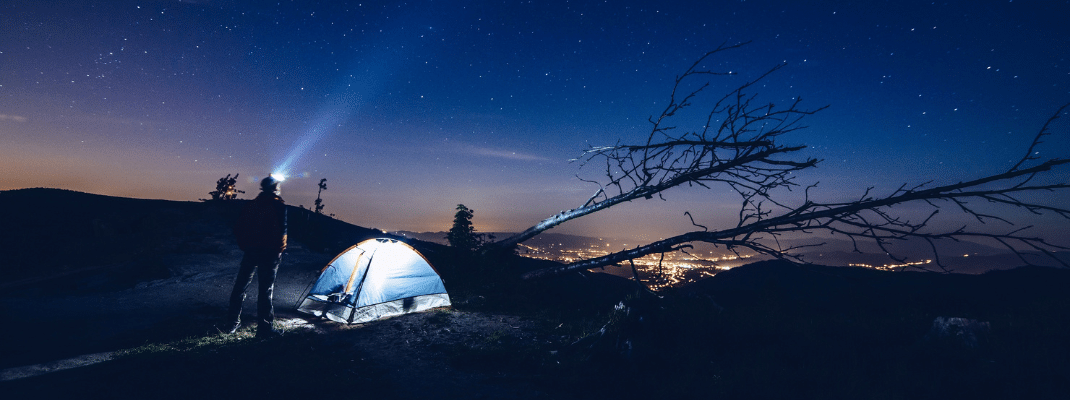 Person using a flashlight while camping