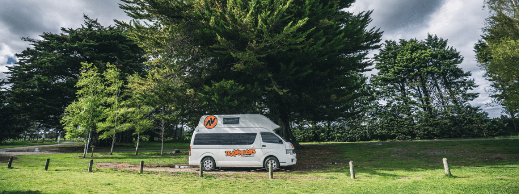 Campervan parked under a tree in New Zealand 