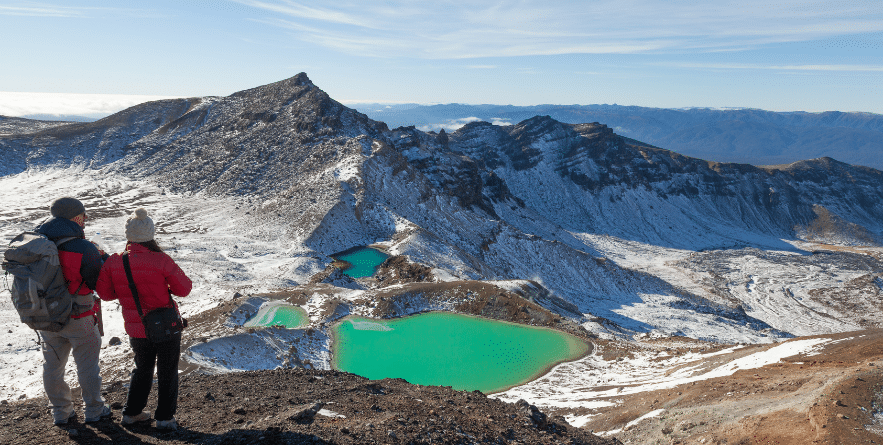 View with a couple of hikers at beautiful Emerald lakes on Tongariro Crossing track, Tongariro National Park, New Zealand